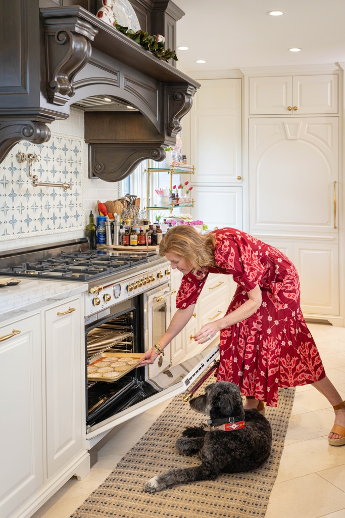 women baking cookies with a dog